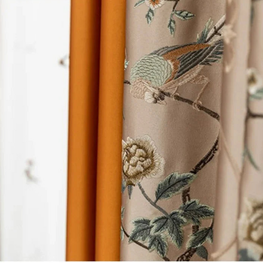 Embroidered fabric with floral and bird design on a beige background